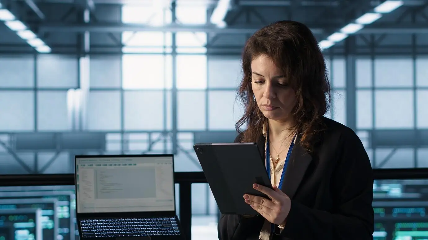 Администратор в центре обработки данных использует на планшете технологии искусственного интеллекта.